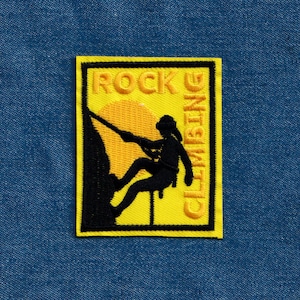 May include: Yellow and black embroidered patch with a silhouette of a person rock climbing with the text "ROCK CLIMBING" on a yellow background.