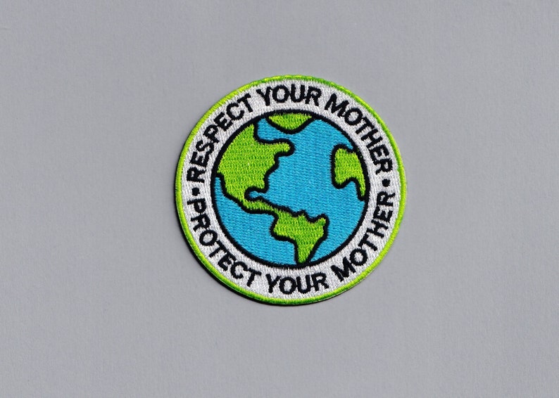 May include: A round green and white embroidered patch with a blue and green globe in the centre. The text around the globe reads "Protect Your Mother - Respect Your Mother".