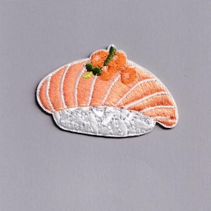 Puede incluir: Parche bordado con un diseño de sushi nigiri de salmón. El parche tiene una cobertura de salmón naranja claro con arroz blanco y está acentuado con detalles naranjas y verdes. El parche tiene un borde blanco y es adecuado para ropa o accesorios.