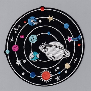 May include: Embroidered patch depicting a solar system with planets, stars, and a comet on a black background.