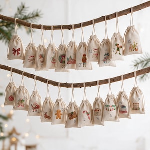 May include: A set of twenty-four small, off-white fabric drawstring bags hanging from two wooden branches. Each bag features a unique Christmas-themed illustration and a printed number from 1 to 24, including images of Santa, reindeer, and gifts.
