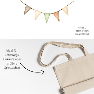 May include: A natural canvas tote bag with a long handle, and a banner of small, watercolor-style pennants in shades of brown, green, and cream. The banner is strung on a thin twine. The bag measures 38cm x 42cm.