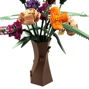 Peut inclure: Un vase en c&eacute;ramique brun avec un design en spirale unique contient un bouquet de fleurs Lego color&eacute;es. Les fleurs comprennent des fleurs roses, violettes, orange et jaunes.