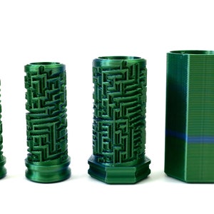 May include: Four green cylindrical containers. Three have a maze-like pattern, and one holds a rolled-up bill. The fourth container is a solid green, hexagonal shape. All are on a white background.