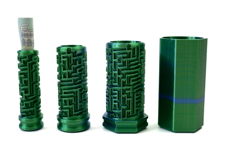 May include: Four green cylindrical containers. Three have a maze-like pattern, and one holds a rolled-up bill. The fourth container is a solid green, hexagonal shape. All are on a white background.