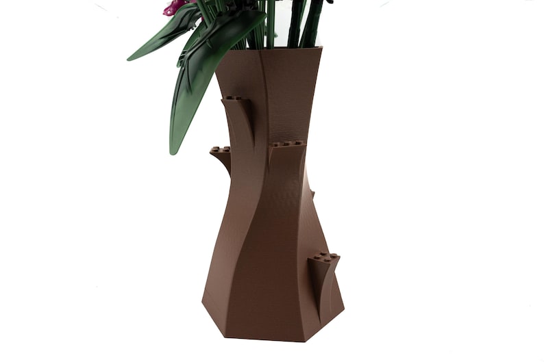 Peut inclure: Un vase en c&eacute;ramique brun avec un design unique et torsad&eacute;. Le vase a une large ouverture en haut et une base &eacute;troite. Il pr&eacute;sente plusieurs petites saillies d&eacute;coratives sur les c&ocirc;t&eacute;s.