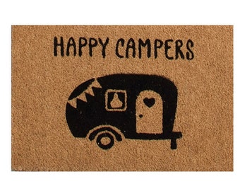May include: A brown coir doormat with the text "HAPPY CAMPERS" in black lettering. A black silhouette of a camper van with a heart-shaped door is below the text.
