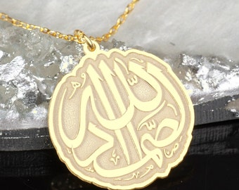 May include: A gold necklace with a round pendant featuring the Arabic word "Allah" in a decorative script.