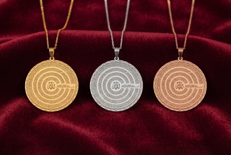 Pu&ograve; includere: Tre ciondoli circolari su sottili catene di metallo, presentati in tonalit&agrave; oro, argento e oro rosa. Ogni ciondolo presenta un simbolo calligrafico arabo centrale circondato da cerchi concentrici di intricati motivi testuali incisi.