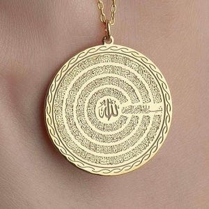 Pu&ograve; includere: Un ciondolo circolare color oro con calligrafia araba incisa in cerchi concentrici. Il centro mostra la parola Allah, circondata da dettagliati motivi di scrittura e da un bordo decorativo con motivo intrecciato.