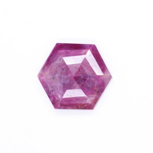 May include: A pink hexagonal gemstone with a faceted cut.