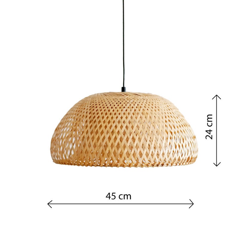 May include: A woven bamboo pendant light fixture. The light is dome-shaped, with a diameter of 45 cm (17.7 inches) and a height of 24 cm (9.4 inches). The light hangs from a black cord.