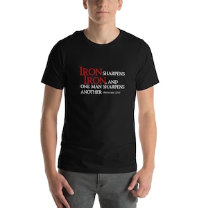 May include: Black t-shirt with a red quote that reads "Iron sharpens iron, and one man sharpens another - Proverbs 27:17"