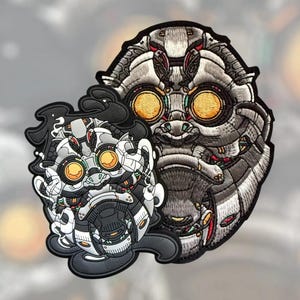 Może przedstawiać: Dwie haftowane naszywki przedstawiające robotyczne twarze. Większa naszywka jest szara z żółtymi oczami i czerwonymi akcentami. Mniejsza naszywka jest biała, szara i czarna z żółtymi oczami. Obie naszywki mają szczegółowy, teksturowany wygląd.