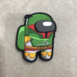 May include: A green, red, and yellow Among Us character in the style of Boba Fett. The character has a green helmet, a black visor, and a white face. The character is wearing green armor with yellow and red accents. The character has a black outline.