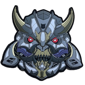 May include: A gray, black, and gold robot head with red eyes and a sharp, toothy mouth. The robot has a samurai-like helmet with horns and a symbol on the forehead.