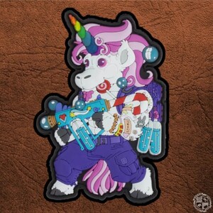 Può includere: Un unicorno bianco con un corno arcobaleno, una criniera rosa e vestiti viola tiene in mano una pistola giocattolo blu e verde. L'unicorno indossa una varietà di accessori, tra cui bastoncini di zucchero, lecca-lecca e uno zaino.