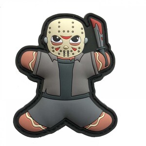 May include: A cartoon-style patch featuring a character in a hockey mask holding a bloody knife. The figure is in a gingerbread man shape, with a gray shirt and pants, and brown accents. The patch has a black border.