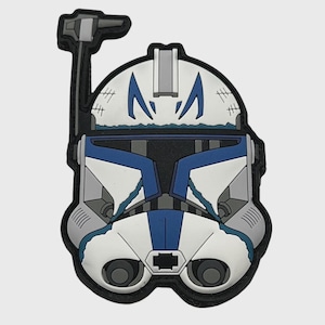 Könnte beinhalten: Ein weißer, blauer und grauer Aufnäher mit einem stilisierten Helmdesign und einem schwarzen Rand. Der Aufnäher hat ein Visier, Markierungen und eine obere Antenne. Das Design erinnert an eine Figur aus einem Science-Fiction-Franchise.