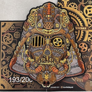May include: A detailed embroidered patch of a steampunk-style Darth Vader helmet with intricate gears and pipes. The patch is brown, gold, and silver with a black background. The patch is numbered 193/200.