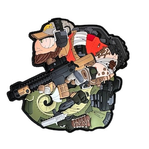 以下が含まれることがあります： 漫画風のパッチ。ひげを生やした兵士が帽子と戦術装備を身につけています。兵士はライフルとナイフを持っています。パッチは緑、茶色、ベージュの色使いで、黒のアクセントがあります。