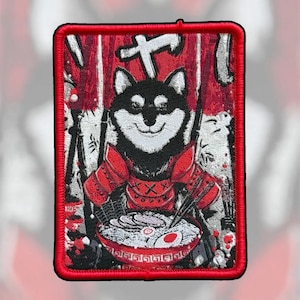 May include: A rectangular embroidered patch featuring a black and white Shiba Inu dog wearing red samurai armor. The dog is positioned behind a large bowl of ramen with chopsticks. The background consists of red and white vertical banners.