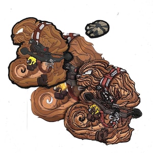 May include: Embroidered patches featuring a brown Wookiee character with a crossbow and a Millennium Falcon patch. The patches have detailed stitching and a textured appearance, with red and brown accents. The patches are on a white background.