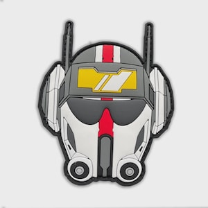 Pode incluir: Um patch detalhado em forma de capacete futurista. O design apresenta um esquema de cores cinza e branco com detalhes em vermelho e amarelo. O capacete tem uma viseira, antenas e uma borda preta.