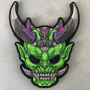 Peut inclure: Un masque de démon vert et violet détaillé avec des cornes, une grande bouche et des dents acérées. Le masque est fait d'un matériau texturé et a un effet 3D.