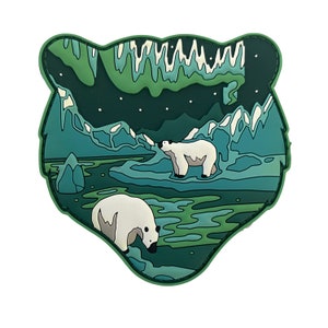 Op de afbeelding: Groene en blauwe geïllustreerde patch met twee witte ijsberen in een besneeuwd landschap onder een groene aurora borealis.