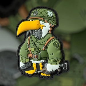 Peut inclure: Un goéland de dessin animé portant un uniforme militaire vert, un casque et tenant un fusil. Le goéland a un bec jaune et des plumes blanches.
