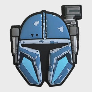 Pode incluir: Um design de capacete Mandaloriano azul e cinzento. O capacete apresenta um aspeto desgastado com detalhes em azul claro e cinzento. O design inclui uma viseira, uma antena e outros detalhes característicos do icónico capacete.