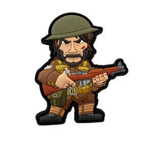 Könnte beinhalten: Eine cartoonartige Figur eines Soldaten in brauner Uniform, olivgrünem Helm und mit einem Gewehr. Der Soldat hat einen ernsten Gesichtsausdruck, einen Bart und eine kleine Wunde im Gesicht. Die Figur hat eine schwarze Umrandung.