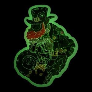 May include: A green and black enamel pin depicting a leprechaun holding a pot of gold. The leprechaun wears a green hat with a shamrock, a red beard, and a military-style jacket. The pin glows in the dark against a black background.