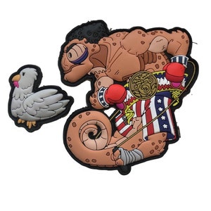 Könnte beinhalten: Zwei Cartoon-Patches: ein weißer Truthahn mit schwarzem Rand und ein muskulöses Chamäleon mit Boxhandschuhen und einem Meisterschaftsgürtel. Das Chamäleon ist braun mit roten, weißen und blauen Akzenten und einem Verband am Arm.