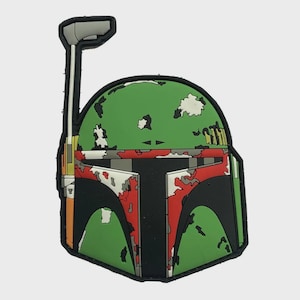 Pode incluir: Um design de capacete Boba Fett verde, vermelho, preto e branco. O capacete apresenta uma base verde com padrões de camuflagem brancos e cinzentos. A viseira é preta, e o design inclui um telémetro e outros detalhes.