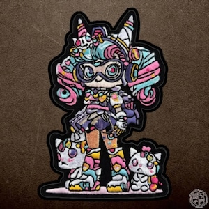 May include: Embroidered patch depicting a vibrant anime-style character with cat-like attributes, wearing goggles and a detailed outfit. The design incorporates pink, blue, yellow, and white, with two small cat companions. The patch has a black border.