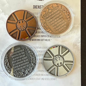 Puede incluir: Cuatro monedas conmemorativas con texto e imágenes en alemán. Las monedas presentan un emblema de águila estilizado y texto dentro de un diseño circular. Las monedas son en tonos cobre, plata y bronce, con una funda de plástico transparente.