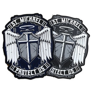 Puede incluir: Dos parches bordados en blanco y negro con las palabras "St. Michael Protect Us" y un escudo con una cruz y alas de ángel.