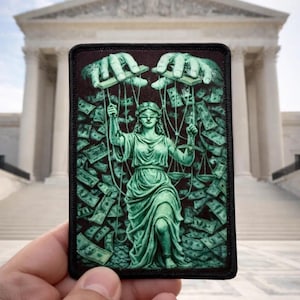 Peut inclure: Un écusson rectangulaire avec une illustration verte de la Justice en marionnette, manipulée par des mains tenant de l'argent. Le fond est rempli de billets de banque. L'écusson a une bordure noire et est tenu devant un bâtiment.