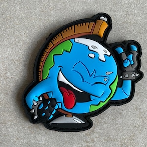 May include: A vibrant patch depicting a cartoon globe with a mohawk and a peace sign. The globe is blue with green continents, a red tongue, and a black border. The character is giving a peace sign with a studded wristband.