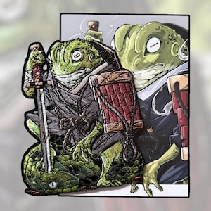 May include: Embroidered patch depicting a green frog samurai with a sword and a bottle. The frog is dressed in a grey kimono, a red and brown shield, and a black hat. A second frog is in the background. The patch has a white border.