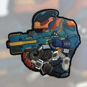 Puede incluir: Un parche colorido que representa a un soldado futurista en cuclillas, sosteniendo un arma grande. El soldado está representado en tonos de azul, naranja y negro, con detalles intrincados. El parche tiene un acabado brillante.