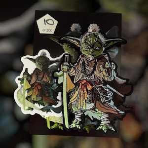 Puede incluir: Parche bordado con un personaje alienígena verde con un sable de luz, vistiendo una túnica marrón. El parche está detallado con varios colores y texturas. El texto "10 of 200" es visible en una etiqueta blanca.