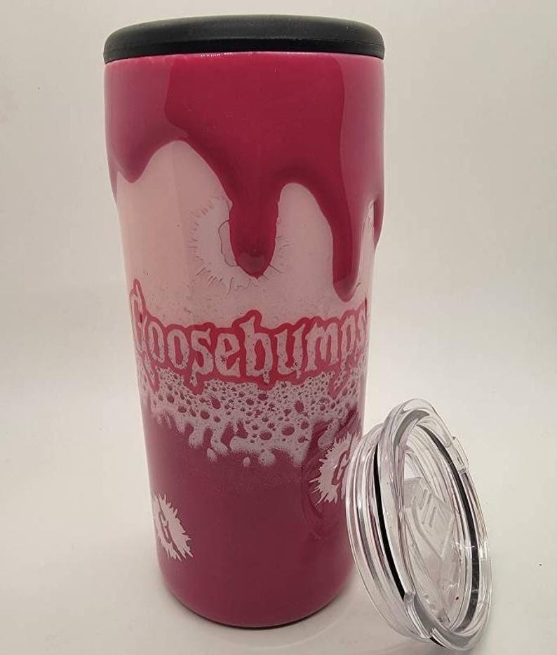 May include: A pink and white stainless steel tumbler with a black lid and a Goosebumps logo. The tumbler has a dripping effect with white foam around the logo.