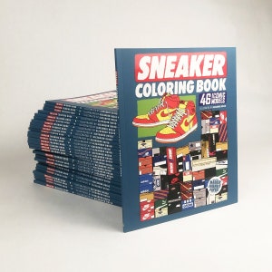 Op de afbeelding: Een stapel kleurboeken met de titel "Sneaker Coloring Book 46 Iconic Models", geïllustreerd door Alexander Rousso. De omslag toont een rode en gele sneaker met een witte zool.