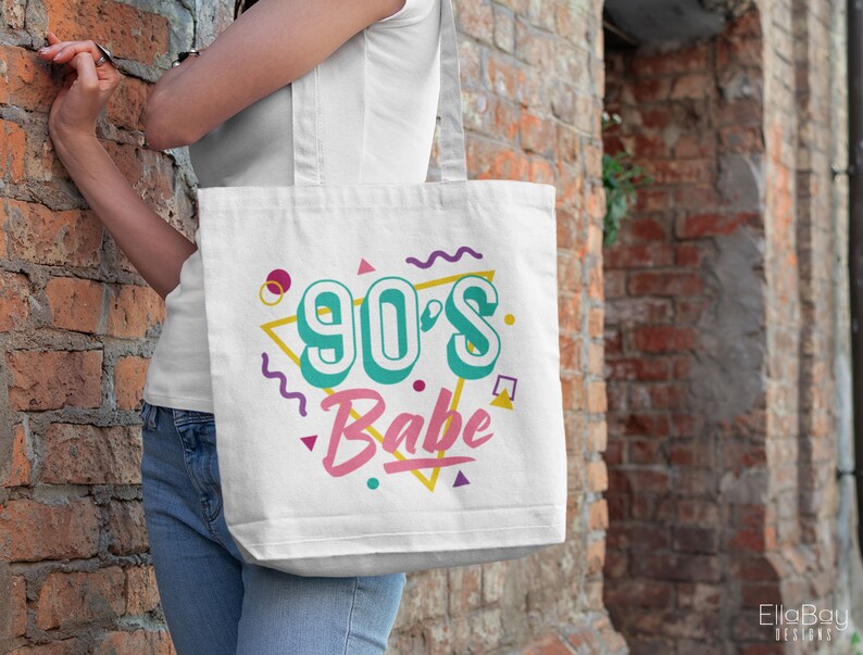 May include: White tote bag with a 90's Babe design in colorful, retro-style lettering and geometric shapes.