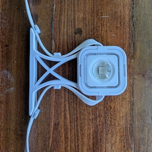 May include: White plastic bike light mount with a white light attached. The light has a clear lens and a small white LED inside.