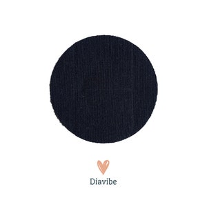 Può includere: Una toppa di tessuto circolare blu navy con una superficie strutturata, su sfondo bianco. Sotto, un cuore color pesca e la parola "Diavibe".