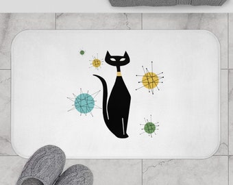 May include: White bath mat with a black cat silhouette and colorful mid-century modern style starbursts.